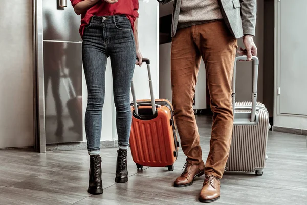 Два стильних партнера тримають свої сучасні валізи — стокове фото