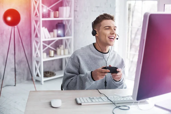 Étudiant beau moderne friand de jeux vidéo se sentir joyeux tout en jouant — Photo