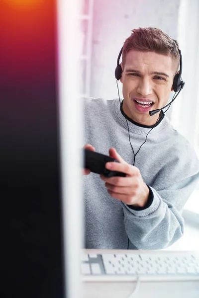 Jovem bonito emocional sentindo curioso ao perder jogo de vídeo — Fotografia de Stock