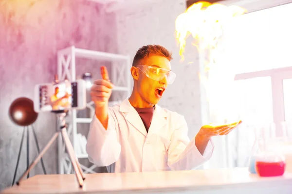 Emocionální student nosí bílý plášť provedení experimentu s ohněm v laboratoři — Stock fotografie