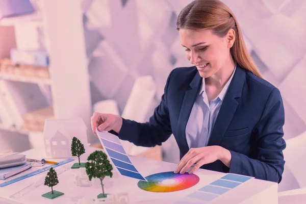 Cheerful female designer considering color at office — Stock Photo, Image