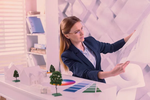 Concerned female architect viewing blueprint at office — Stock Photo, Image