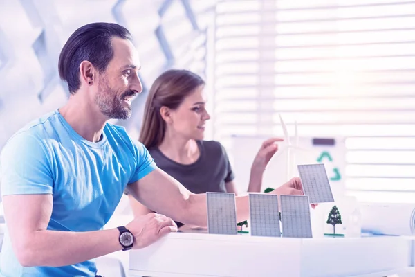 Feliz eco ingeniero sonriendo blanco colocando pequeñas baterías solares — Foto de Stock