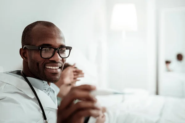 Joyful pessoa do sexo masculino de pele escura que trabalha na clínica — Fotografia de Stock