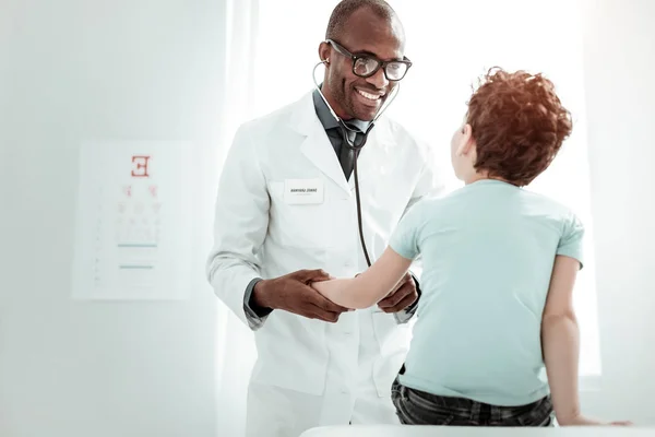 Praticante encantado positivo que trabalha na clínica com pacientes — Fotografia de Stock