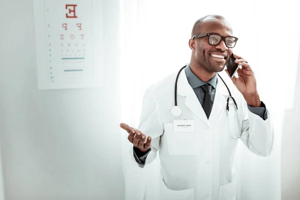 Glædelig international læge, der taler på mobiltelefon - Stock-foto