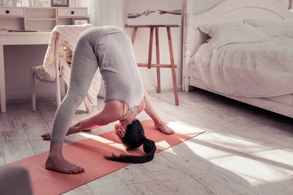 Vrouw beoefenen van yoga voor haar rug spieren uit te rekken — Stockfoto