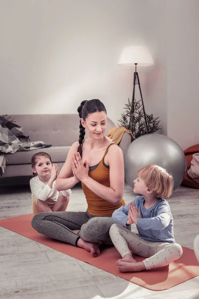 Niños haciendo yoga en casa con su madre —  Fotos de Stock