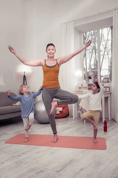 Mor undervisning barn att hålla balansen i en yoga position — Stockfoto