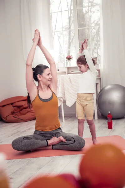 Madre enseñando a su hija pequeña yoga posa —  Fotos de Stock
