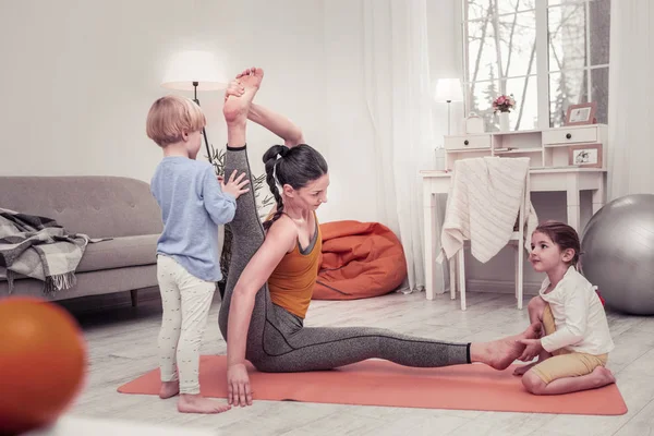 Niños ayudando a su madre a hacer ejercicios de estiramiento — Foto de Stock