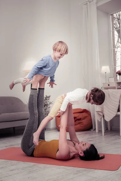 Crianças gostando de fazer exercícios de ioga com sua mãe — Fotografia de Stock