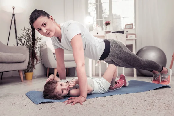 Mulher fazendo flexões junto com sua filha — Fotografia de Stock