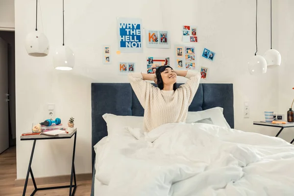 Sötét hajú sugárzó nő felébred a kényelmes szobájában — Stock Fotó