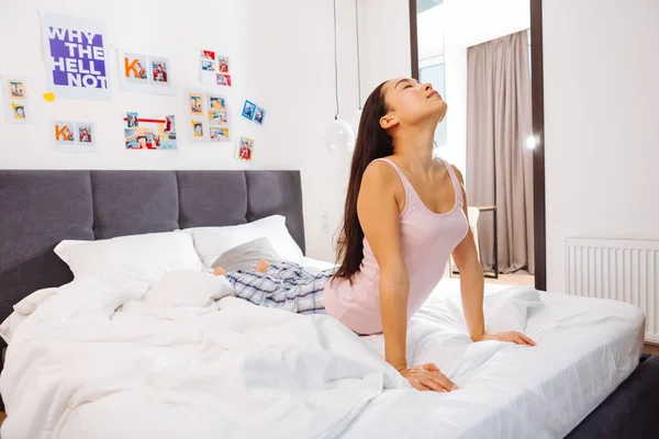 Mulher magra com cabelos longos sentindo-se bem fazendo ioga matinal — Fotografia de Stock