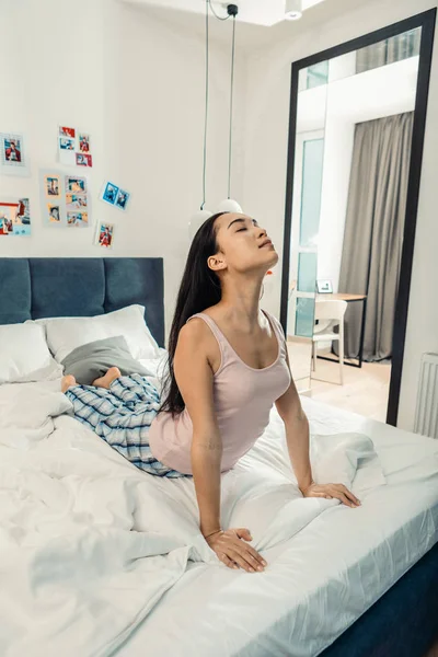 Mujer de cabello oscuro usando pijama cómodo haciendo ejercicios matutinos — Foto de Stock