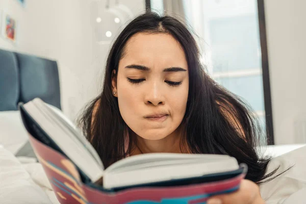 Mujer sintiéndose reflexivo mientras lee libro filosófico — Foto de Stock