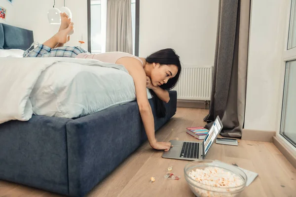 Freelancer trabajando en su portátil después de comer maíz pop — Foto de Stock