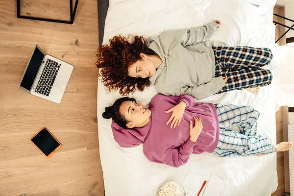 Två kvinnor söker härlig medan klädd i pyjamas och talar — Stockfoto