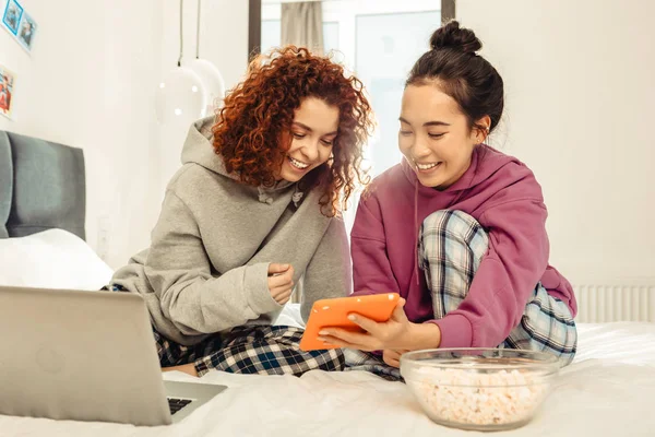 Två bästa vänner titta rolig video på den på deras orange tablett — Stockfoto