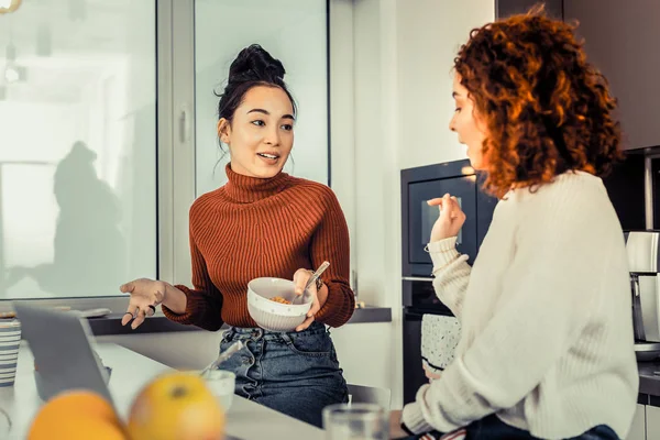 Magro companheiro de quarto de olhos escuros comendo seu café da manhã com amigo — Fotografia de Stock