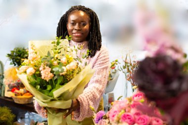 Kind dark-skinned woman demonstrating unordinary natural bouquet clipart