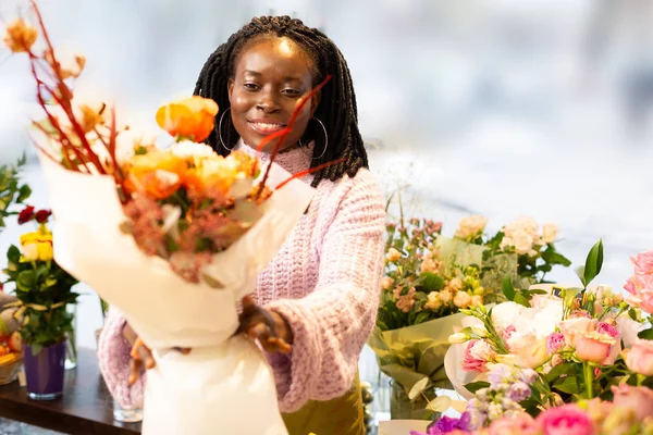 Piacevole decoratore internazionale guardando dritto ai fiori — Foto Stock