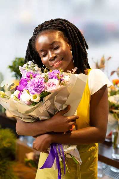 Gentile giovane bruna femminile abbracciando bouquet straordinario — Foto Stock