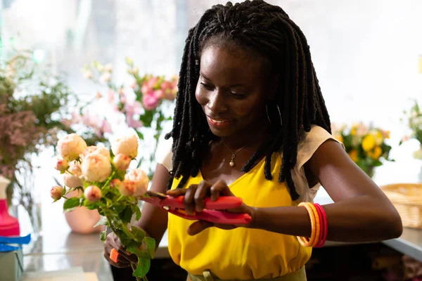 Allegro ragazza dalla pelle scura prendersi cura di fiori — Foto Stock