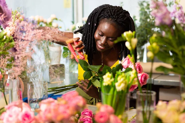 Bella fiorista internazionale prendersi cura dei fiori — Foto Stock