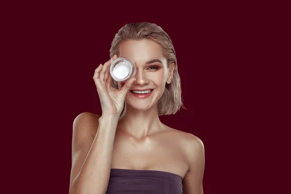 Joven modelo sonriendo mientras que la promoción de su crema favorita — Foto de Stock