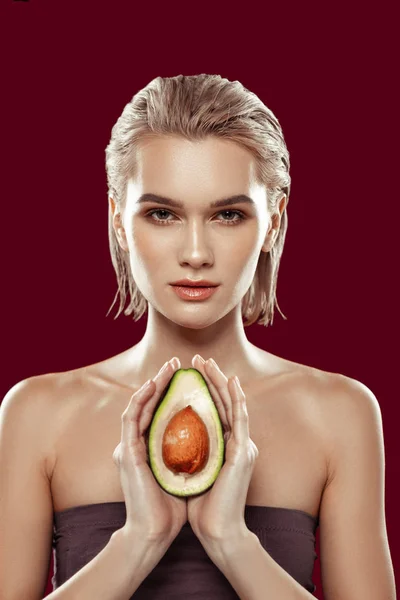 Slim professional model showing avocado posing for food magazine
