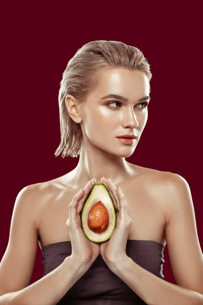 Slim model wearing open shoulder top holding nice avocado — Stock Photo, Image