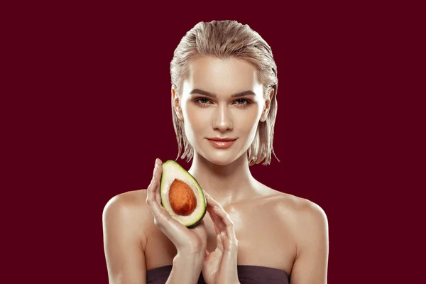 Modelo con corte bob que tiene buen maquillaje mientras posa con aguacate — Foto de Stock