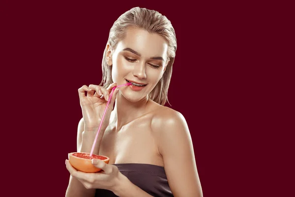 Mujer de cabello rubio bebiendo un poco de jugo de pomelo sabroso — Foto de Stock