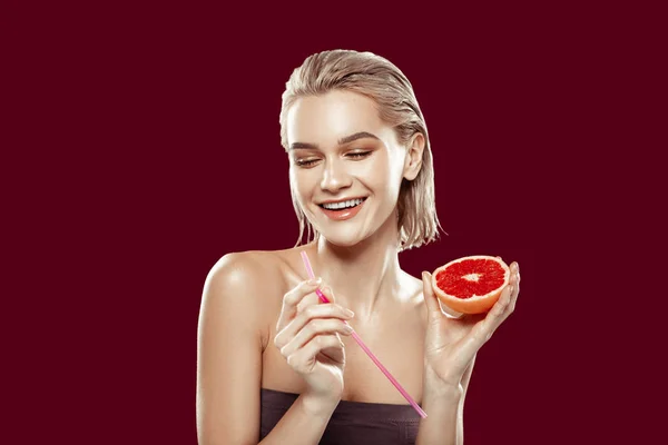 Young photo model feeling cheerful posing with grapefruit