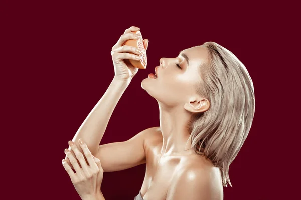 Blonde modèle serrant un peu de jus de pamplemousse dans sa bouche — Photo
