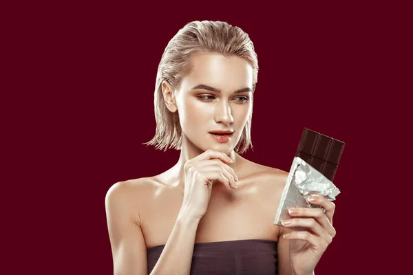 Modelo participando en campaña de dieta saludable mirando el chocolate — Foto de Stock