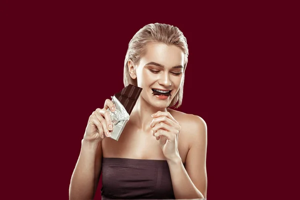 Slim atractiva sensación de modelo alegre mientras come chocolate — Foto de Stock