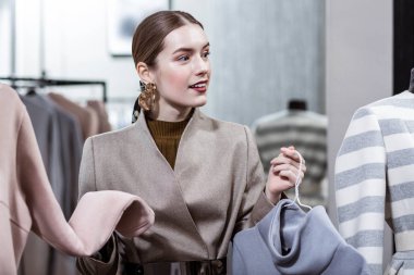 Şık uzun saçlı genç gülümseyen kadın ile büyük küpeler düşünceli arıyorum