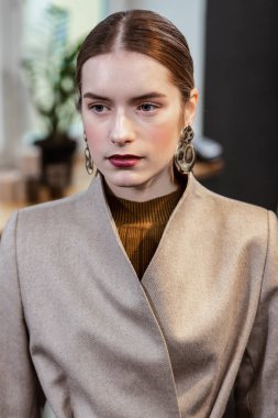 Güzel uzun saçlı güzel kadın ciddi seyir büyük küpeli