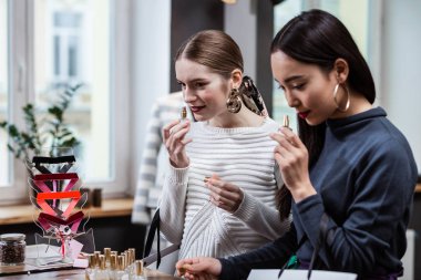 Büyük küpeler ve yeni kokuları tartışırken bir esmer kız çok uzun saçlı güzel kadın