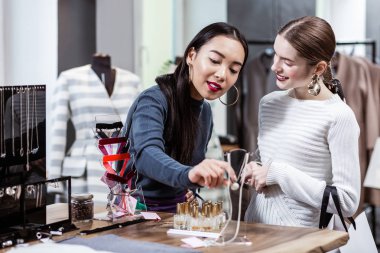 Esmer güzel Asyalı kadın bir donanma polo boyun ve arkadaşı süslemeler seyir