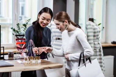Esmer güzel Asyalı kadın bir donanma polo boyun ve arkadaşı süslemeler tartışıyor