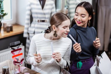 Yeni bir parfüm test bir beyaz kazaklı gülümseyen güzel uzun saçlı kadın