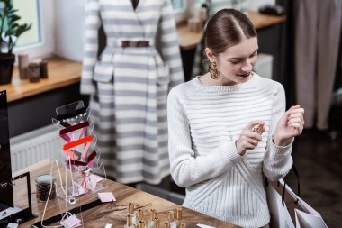 Uzun saçlı sevimli Bayan parfüm seçimi beyaz kazak