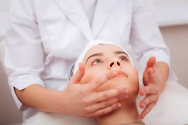 Profesyonel bir yüz masajı sahip güzel genç kadın