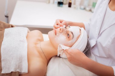 Profesyonel güzel güzellik uzmanı bir kil maskesi kaldırma