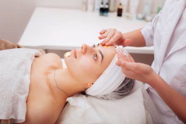 Altın maske sayfaları tutan profesyonel kadın güzellik uzmanı