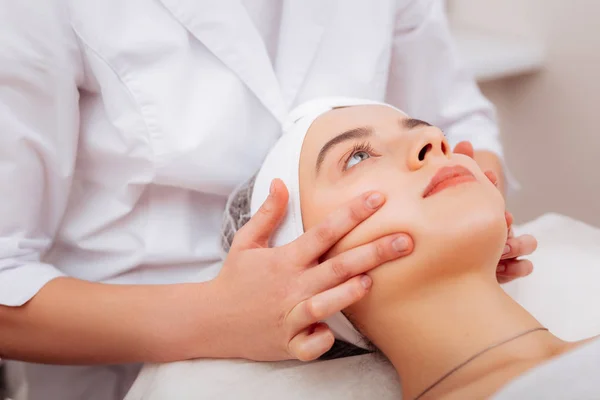 Närbild av kosmetologer hand röra klienter ansiktet — Stockfoto